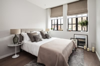 A contemporary luxury bedroom at The Maple Building in Kentish Town with statement Clement metal windows.