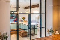 This bespoke, stylish Clement steel screen divides this kitchen and dining area and creates a stunning feature.